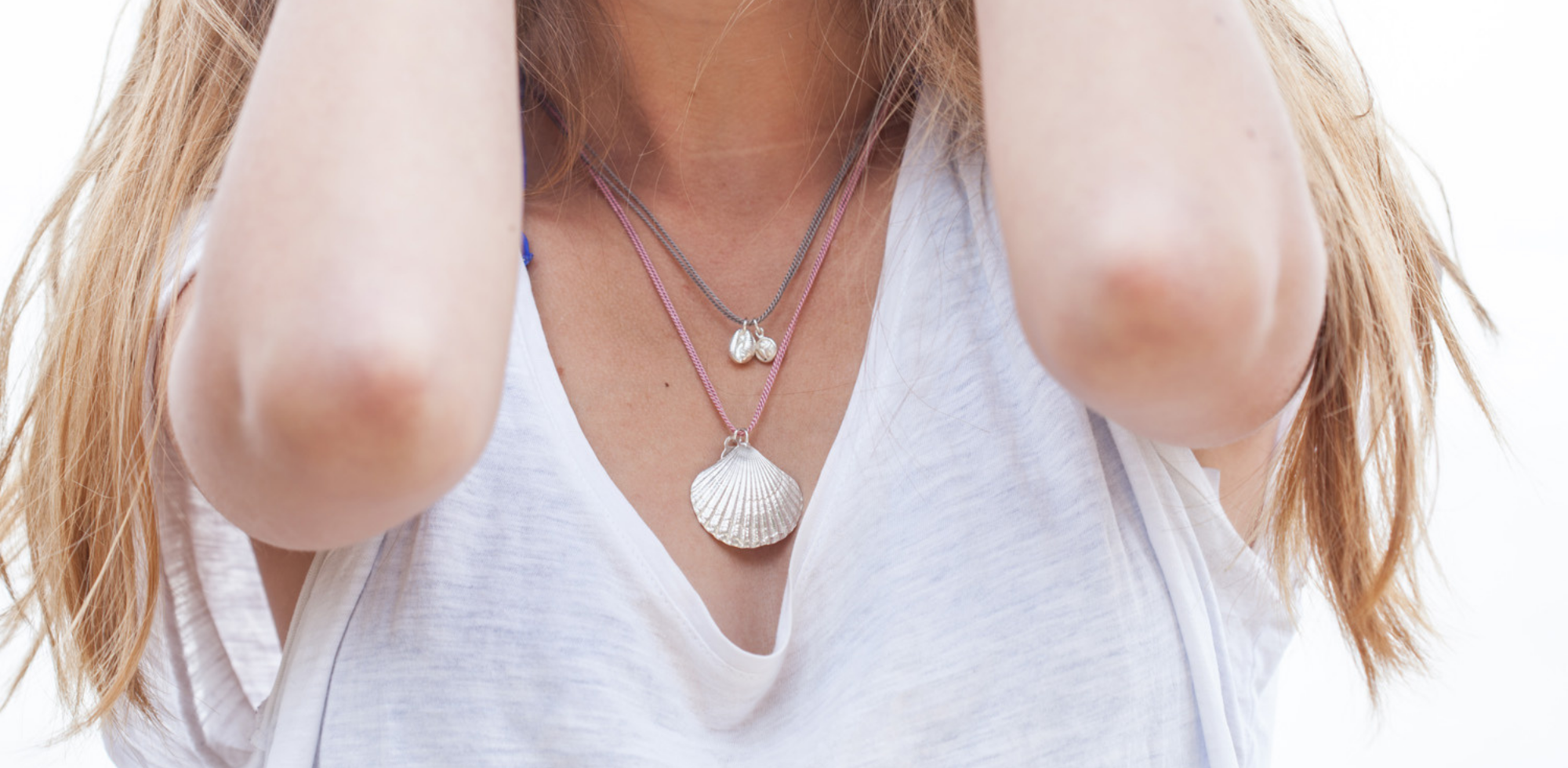 Handmade silver scallop shell and cowrie shell necklaces by Helen Butler Designs inspired by nature, movement and coastal surroundings