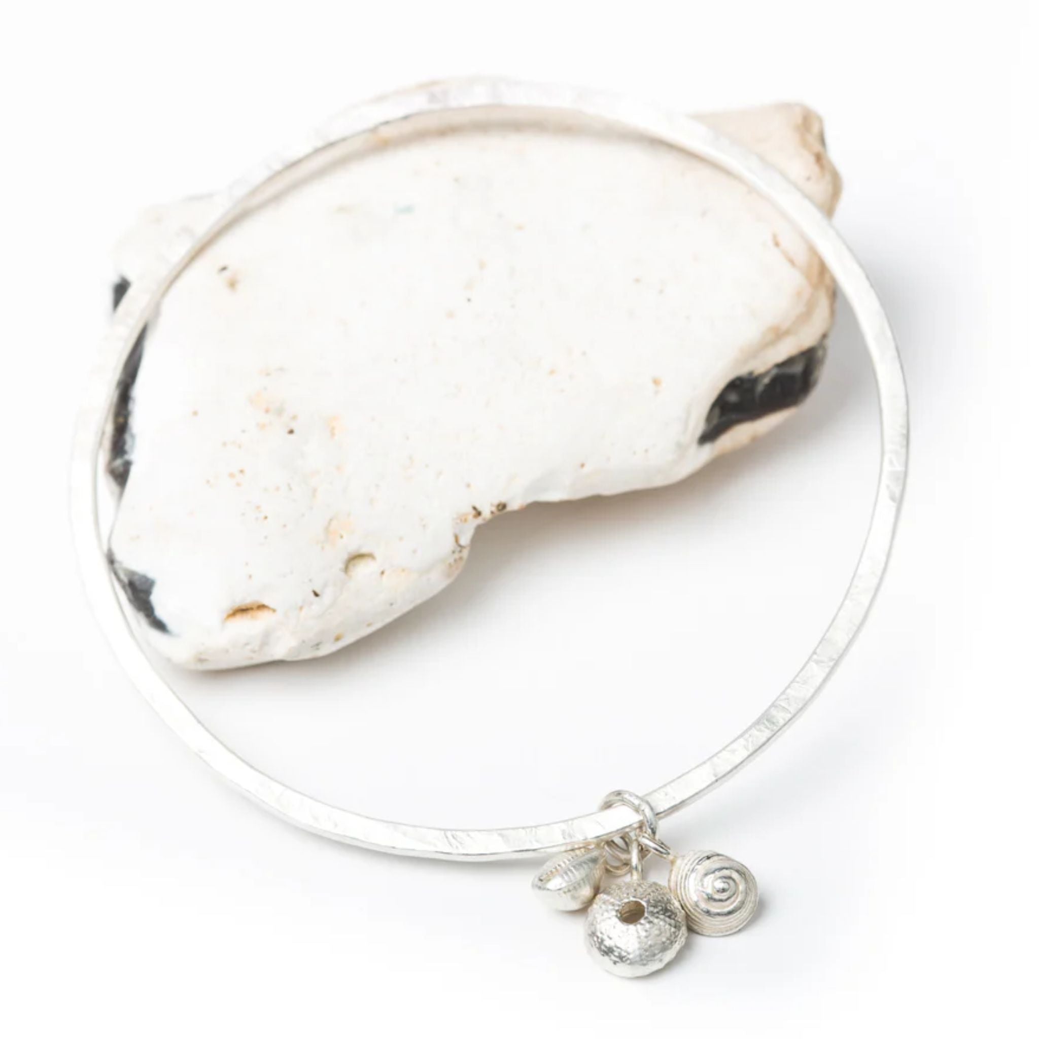Silver bracelet with a small charm on a white background